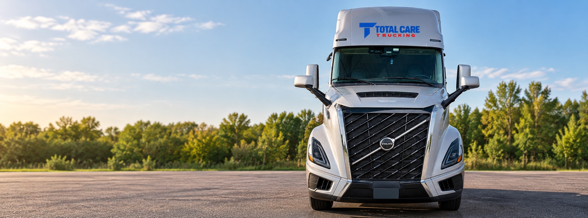 Edited photo of the owner's silver Volvo truck with Total Care Trucking branding in a clean outdoor setting